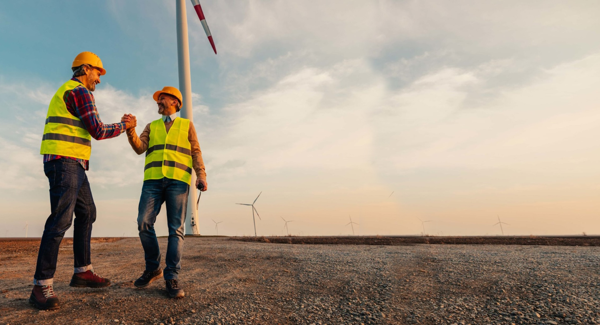 parter-withus-final Renewable energy technicians celebrating success near wind turbines
